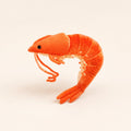 A small plush toy shrimp in bright orange-red fabric, posed on a plain off-white background.