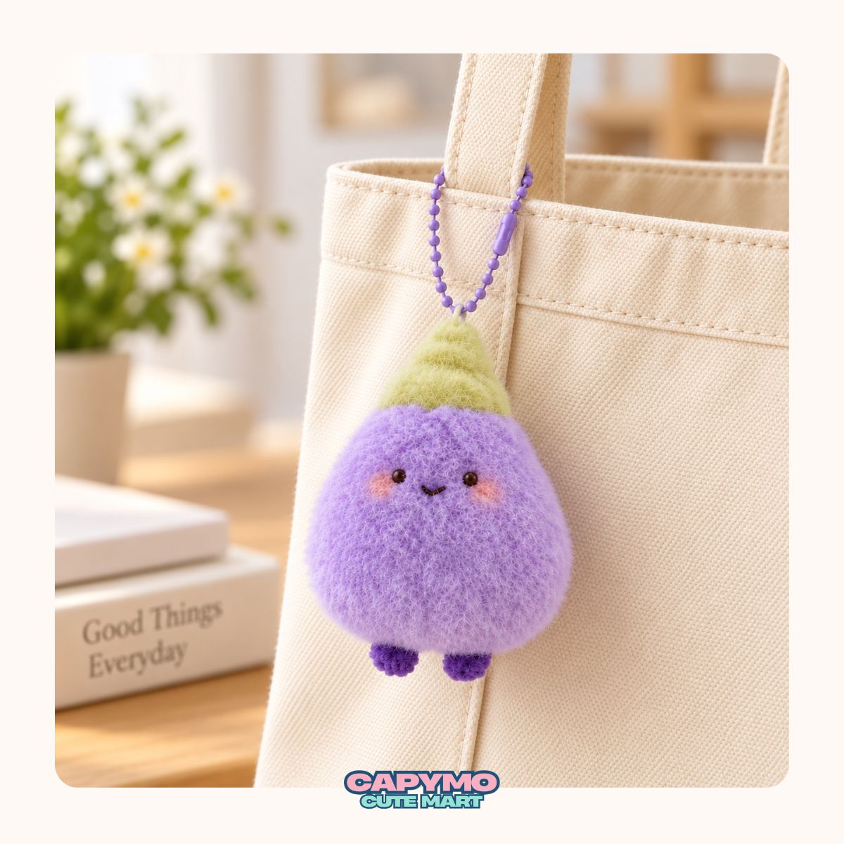 A cute purple plush avocado keychain with a green top and a beaded purple chain, hanging from a beige canvas tote bag in a softly blurred indoor setting.