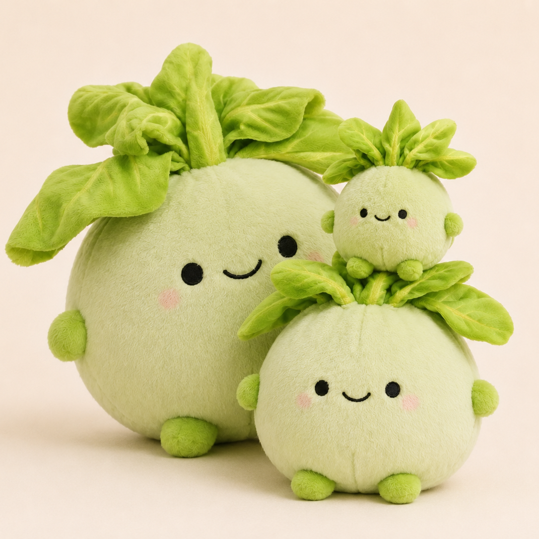 Three cute plush vegetables in different sizes, featuring light green bodies, bright green leafy tops, and smiling faces, set against a solid pale pink background.