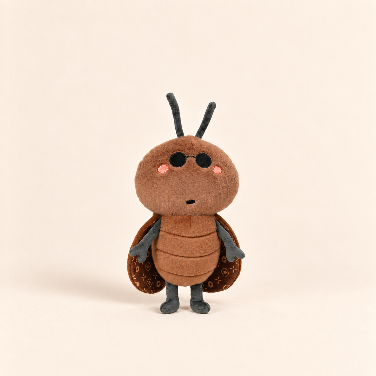 A cute, soft plush toy of a brown beetle or bug character, standing against a solid, warm off-white background.