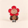A cute plush toy designed like a flower bug, featuring a brown textured body, a red flower crown, and small gray legs and hands, standing against a solid light beige background.