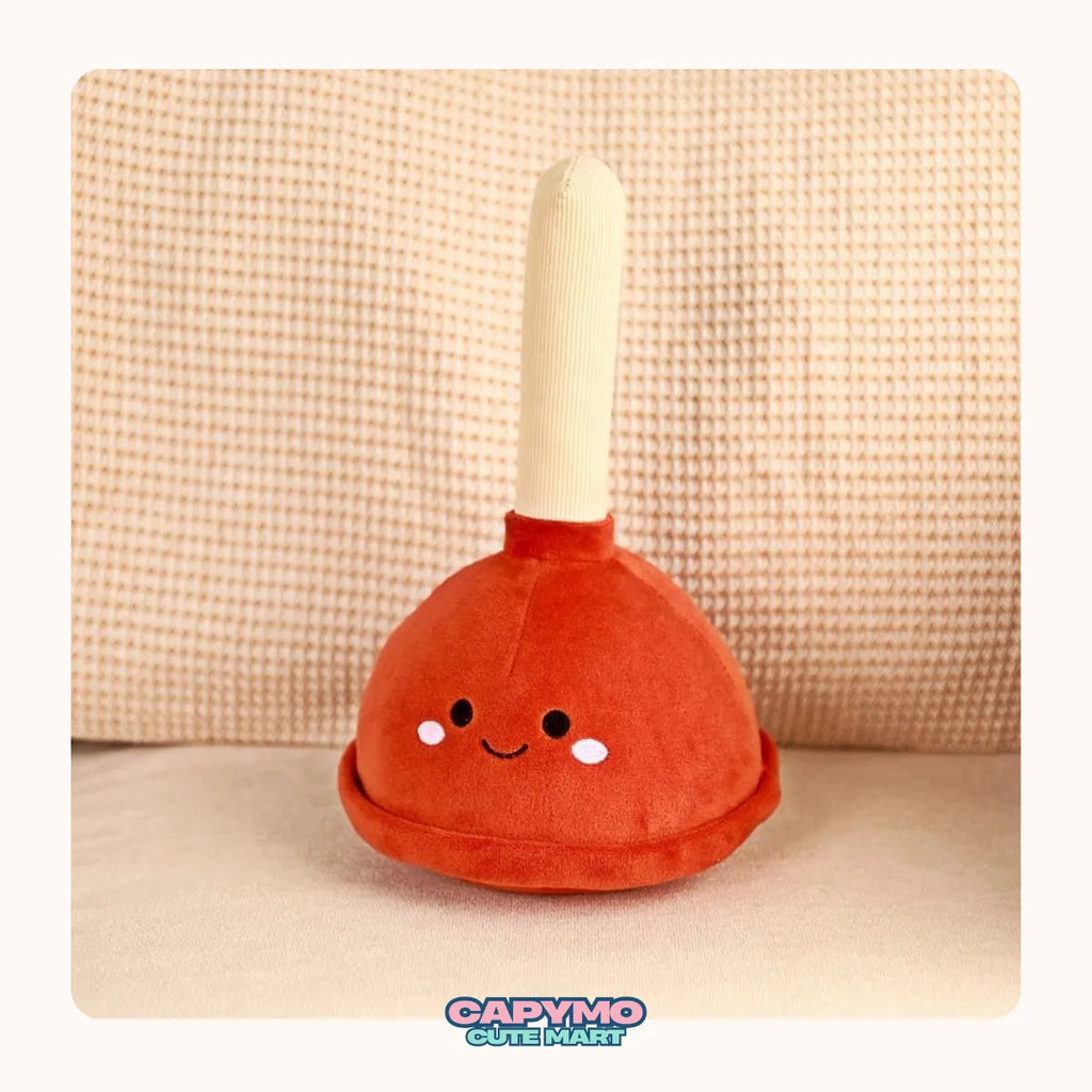 Plush toy resembling a plunger with a happy face on a beige background, branded 'Capymo'.